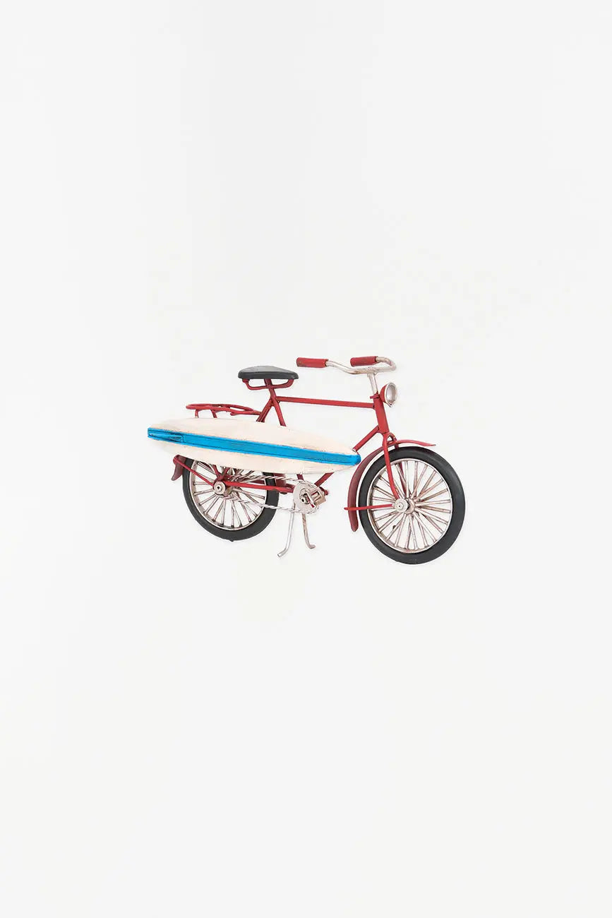 Bicicleta decorativa roja con tabla de surf