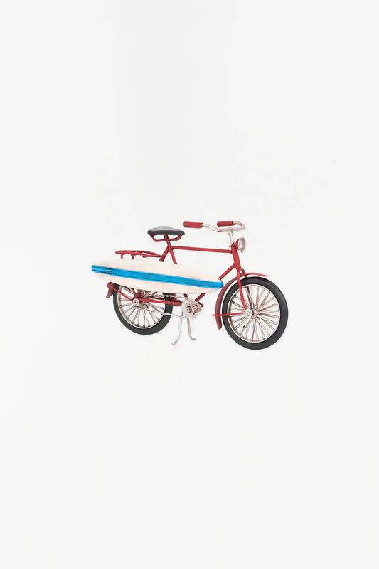 Bicicleta decorativa roja con tabla de surf