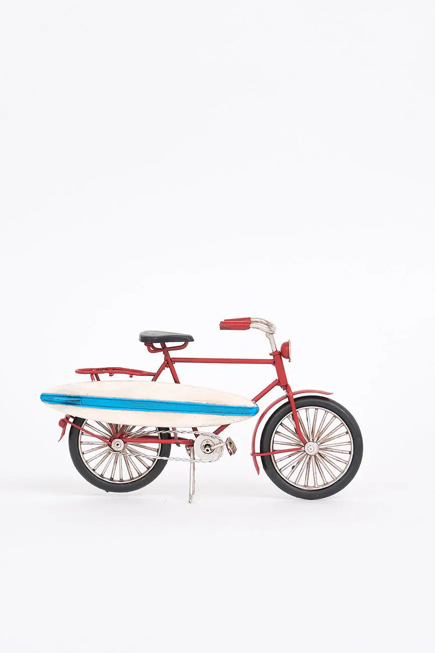 Bicicleta decorativa roja con tabla de surf