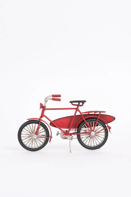 Bicicleta decorativa roja con tabla de surf