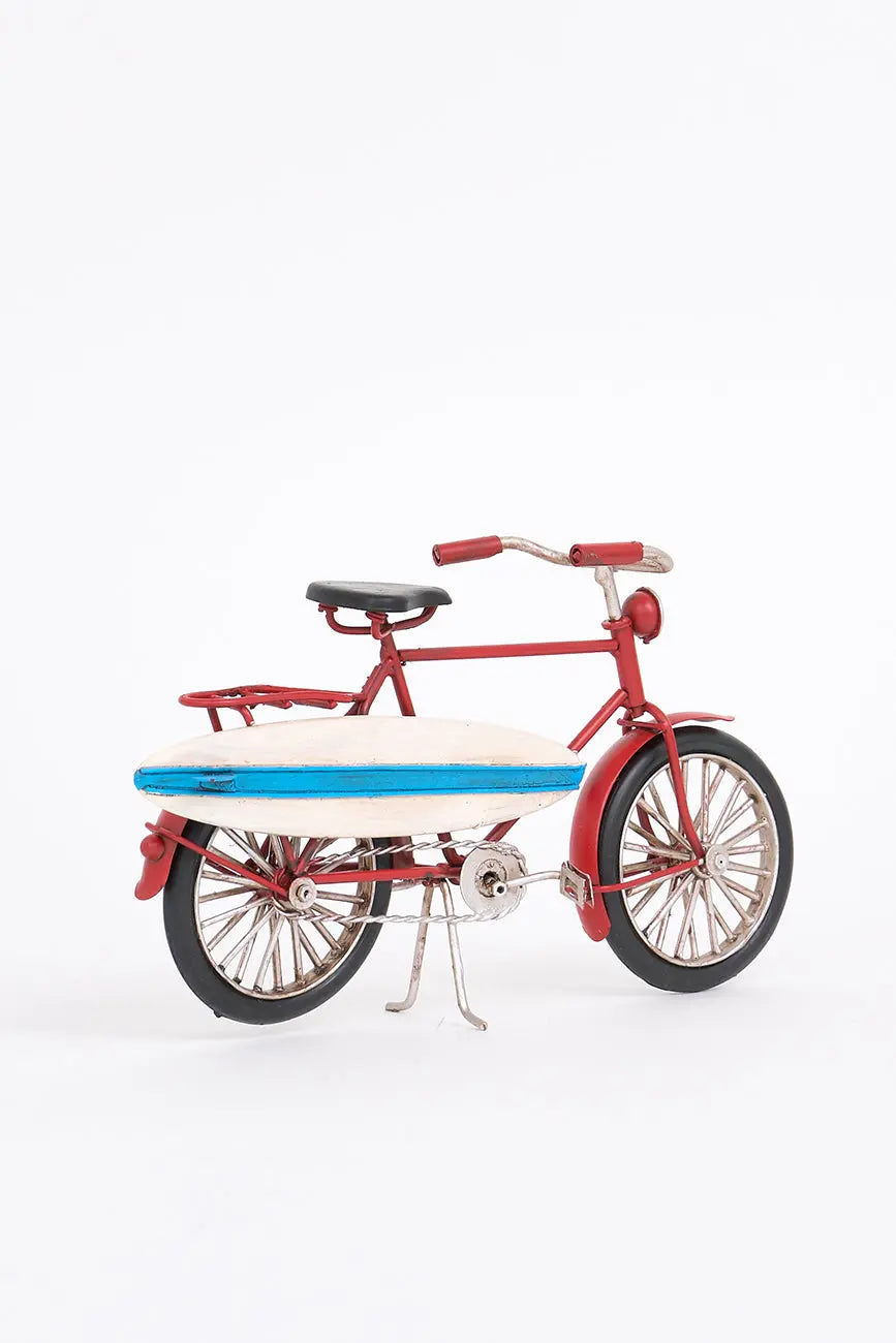Bicicleta decorativa roja con tabla de surf