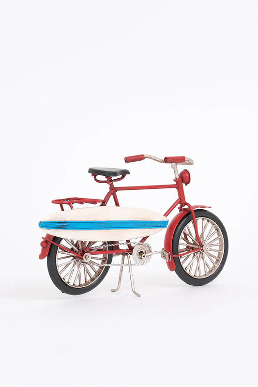 Bicicleta decorativa roja con tabla de surf