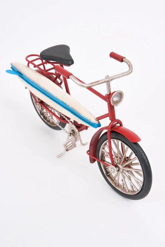 Bicicleta decorativa roja con tabla de surf