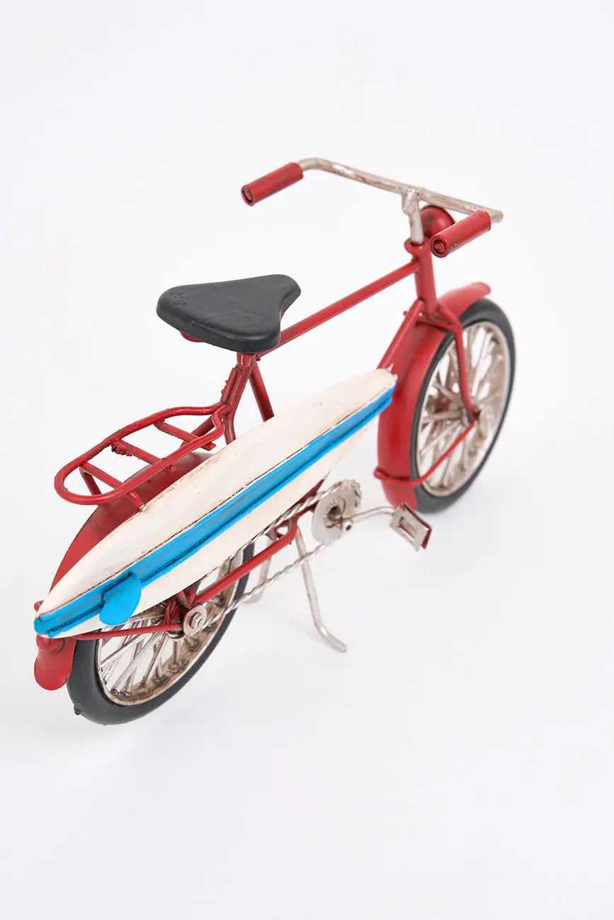 Bicicleta decorativa roja con tabla de surf