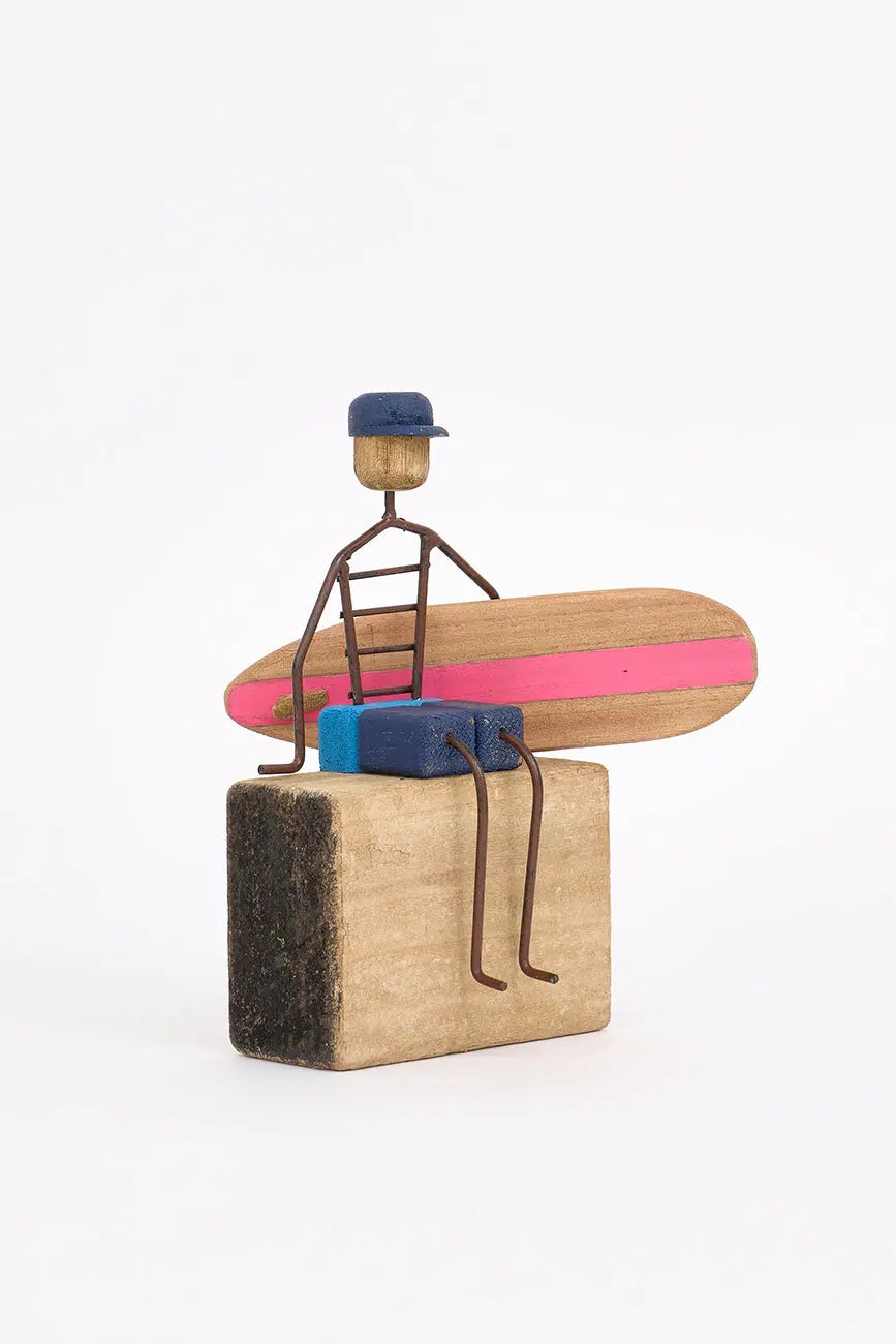 Figura de surfero sentado de metal y madera
