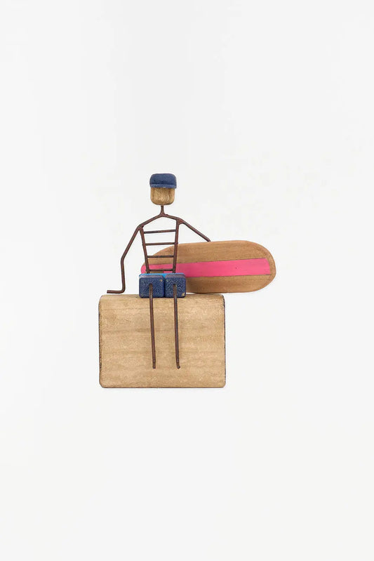 Figura de surfero sentado de metal y madera