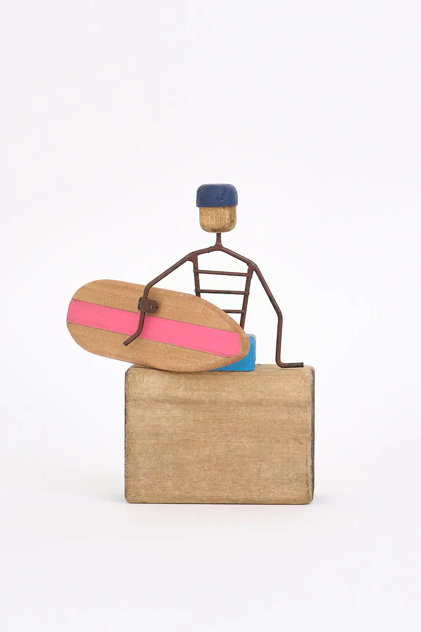 Figura de surfero sentado de metal y madera