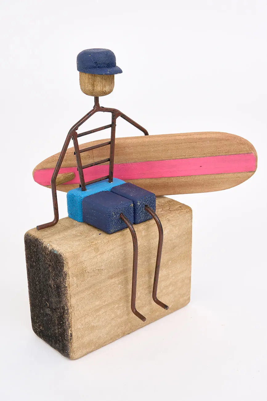 Figura de surfero sentado de metal y madera