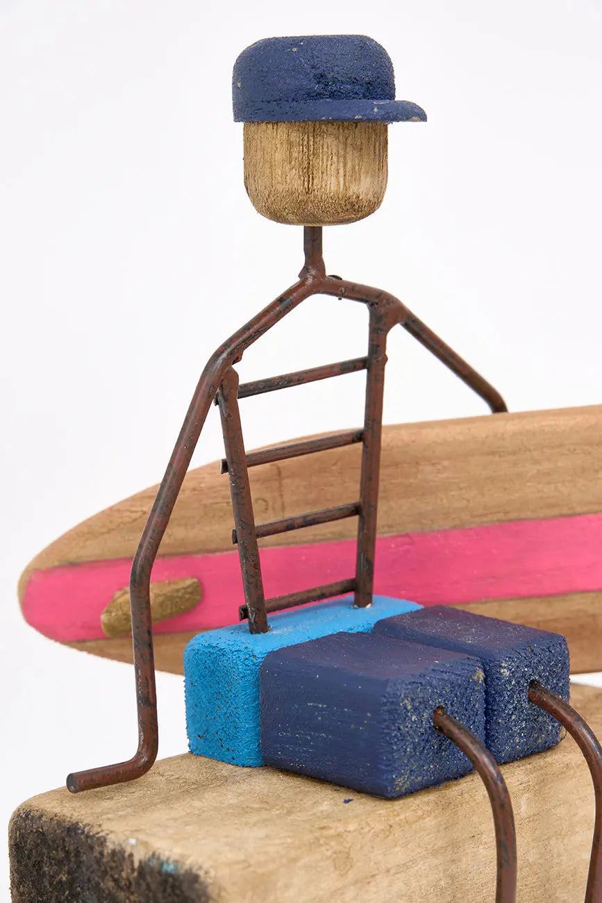 Figura de surfero sentado de metal y madera