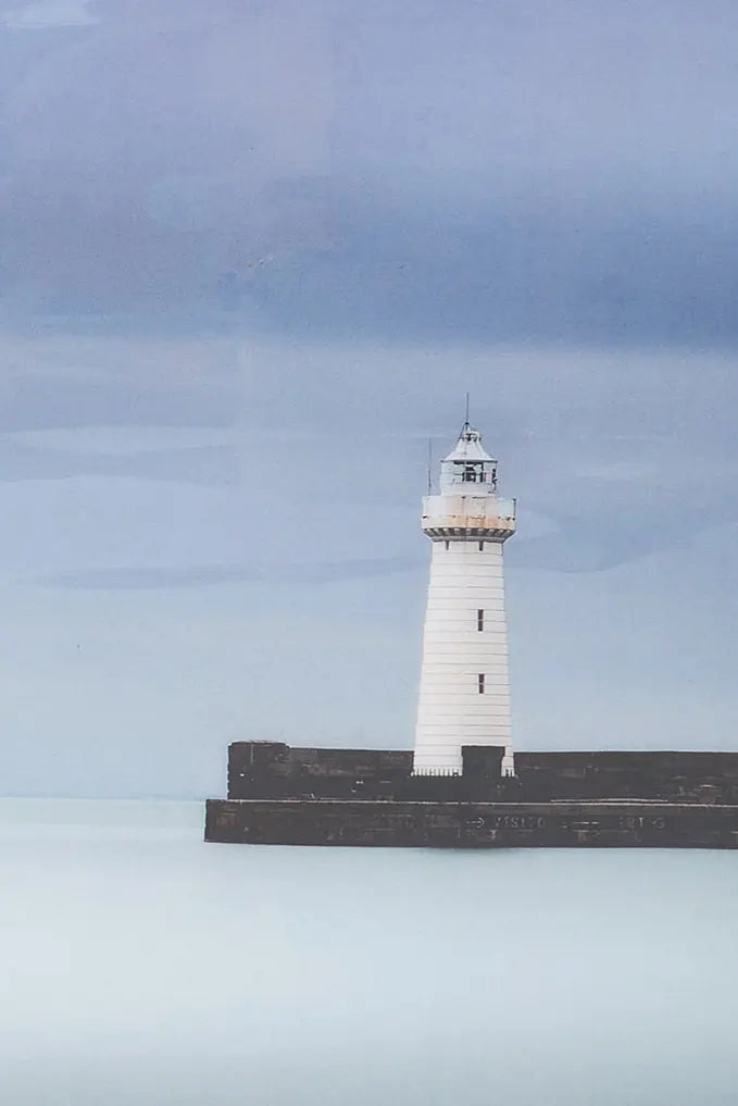 Foto impresa sobre taco de madera. Puerto con faro