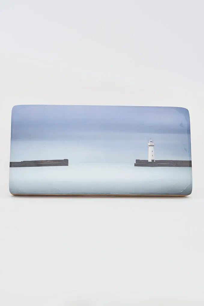 Foto impresa sobre taco de madera. Puerto con faro