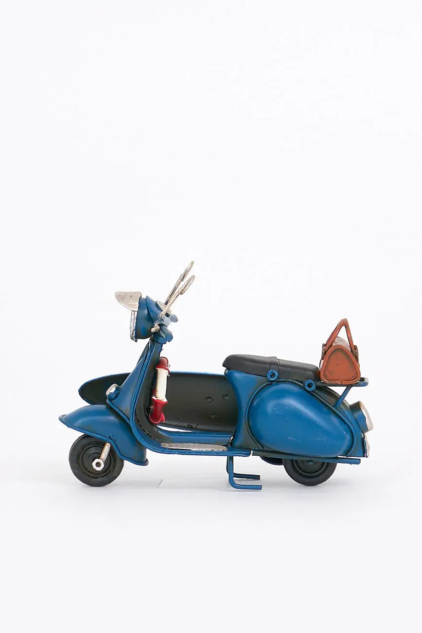 Moto vespa azul con tabla de surf