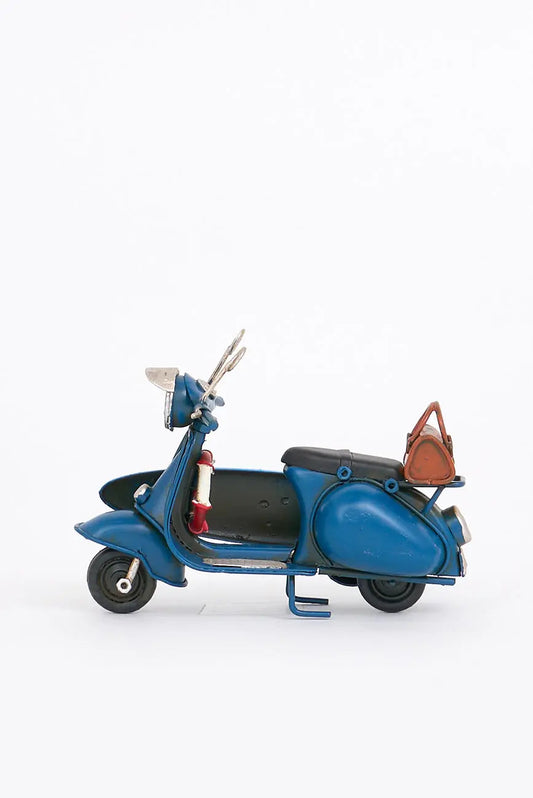 Moto vespa azul con tabla de surf