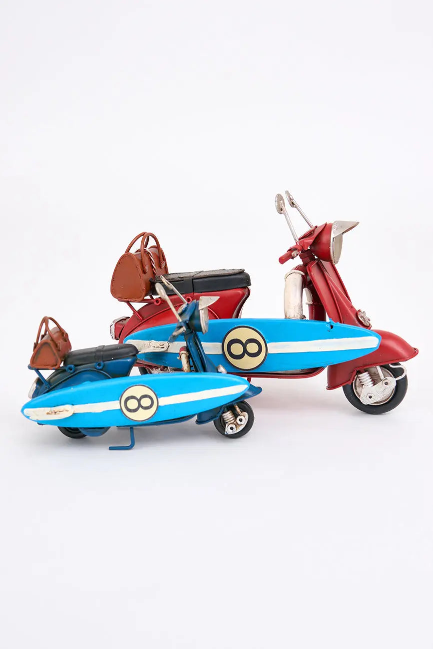 Moto vespa azul con tabla de surf