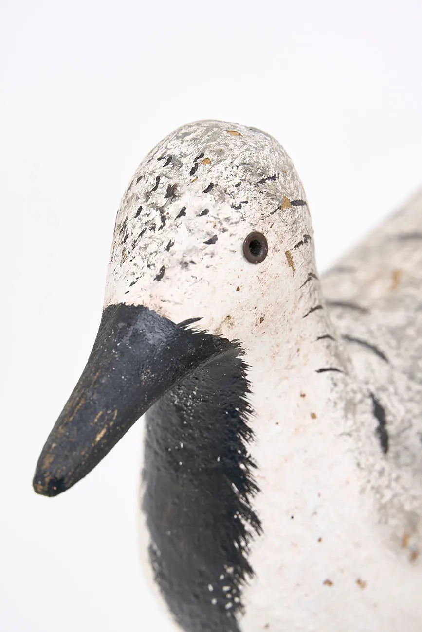 Pájaro de madera en tonos blancos, negros y grises