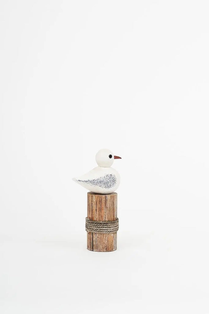 Pájaro de madera sobre tronco Batela