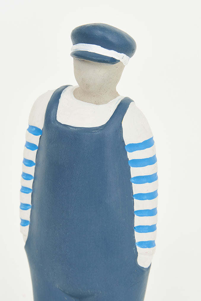 Figura de cemento marinero con peto y gorra azul